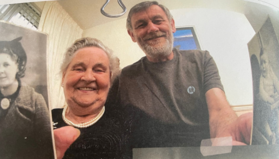 A photo of Molly and Ronnie French holding photos of their younger selves.