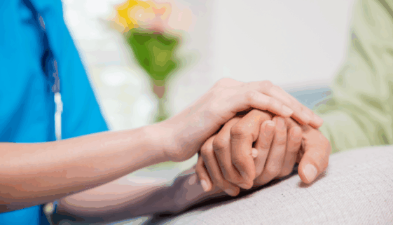 Healthcare worker holding a patient's hand