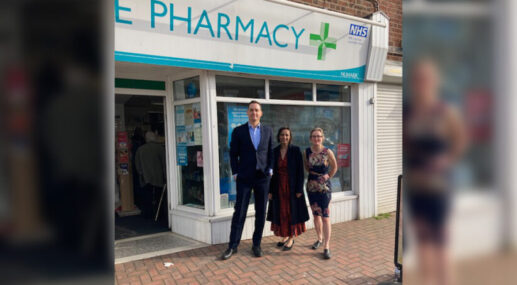 three people standing in front of a pharmacy